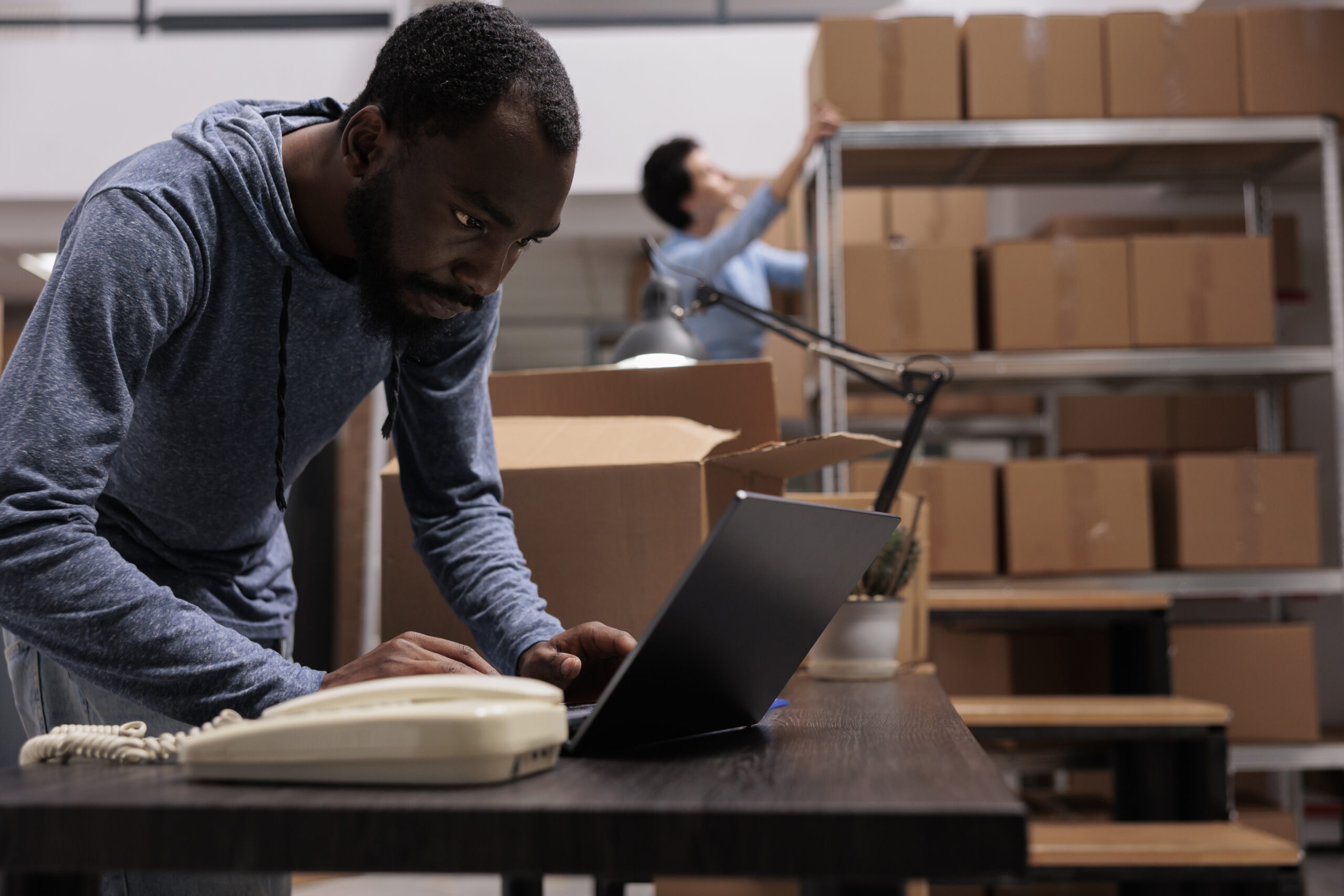 african-american-employee-looking-cargo-stock-before-start-preparing-customers-orders-working-warehouse-delivery-department-worker-checking-shipping-detalies-laptop-computer