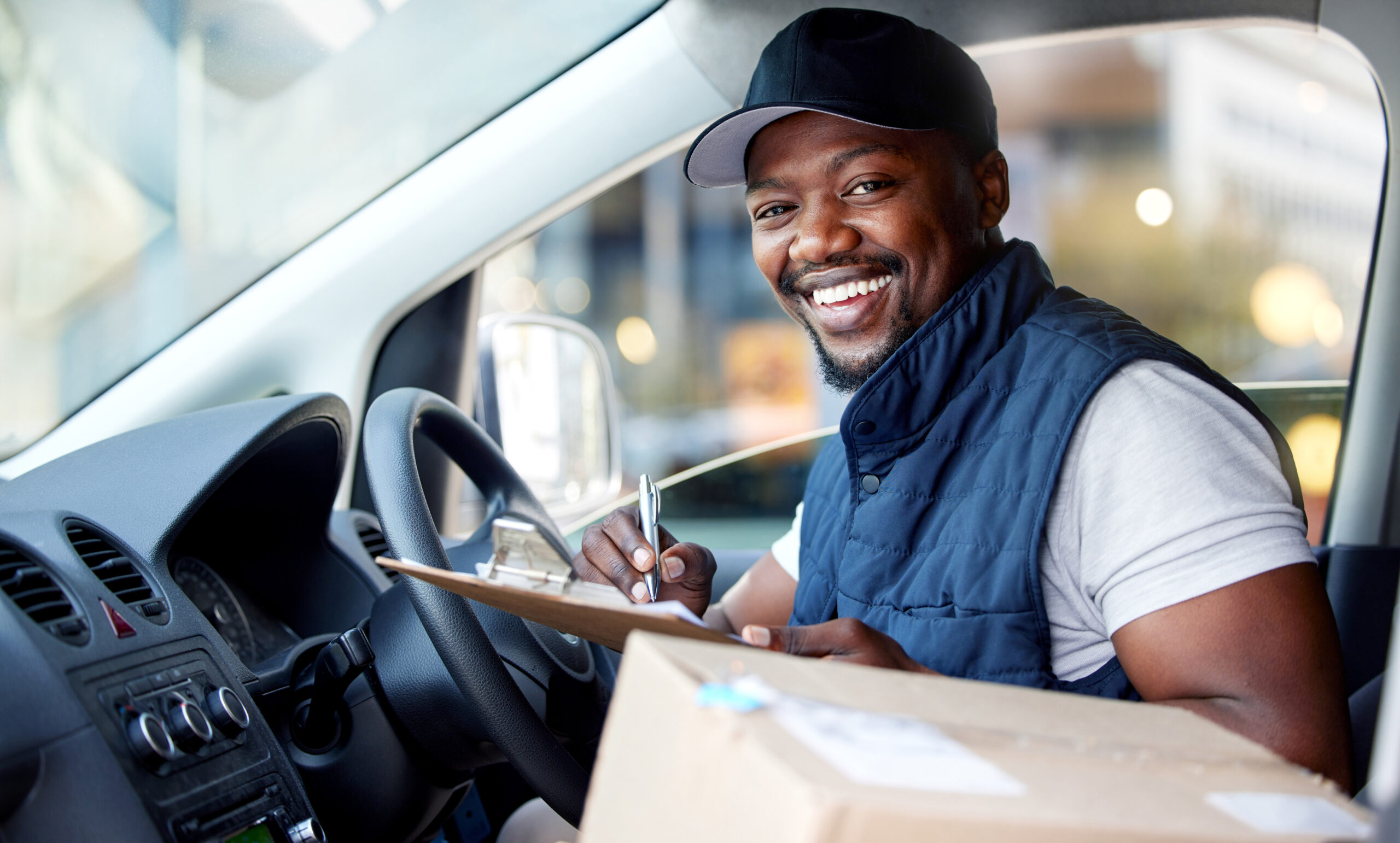 delivery-man-transport-portrait-man-writing-with-smile-window-shipping-courier-service-happy-black-person-driver-with-cardboard-package-sign-paper-van-cargo-vehicle