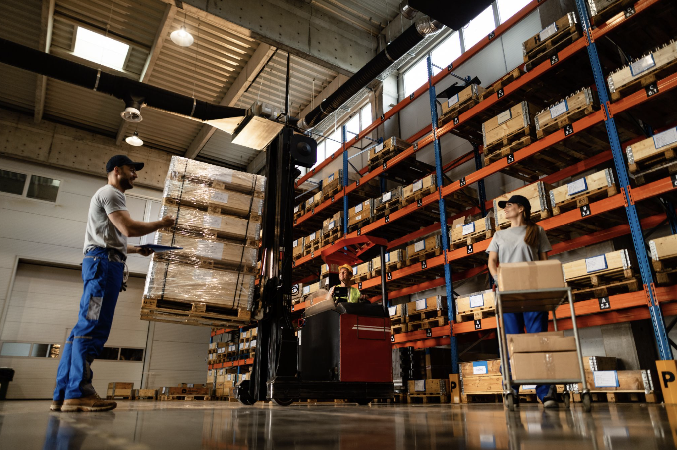 Warehouse workers managing stock movement with a warehouse management system to support integration, transport workflows and reporting.